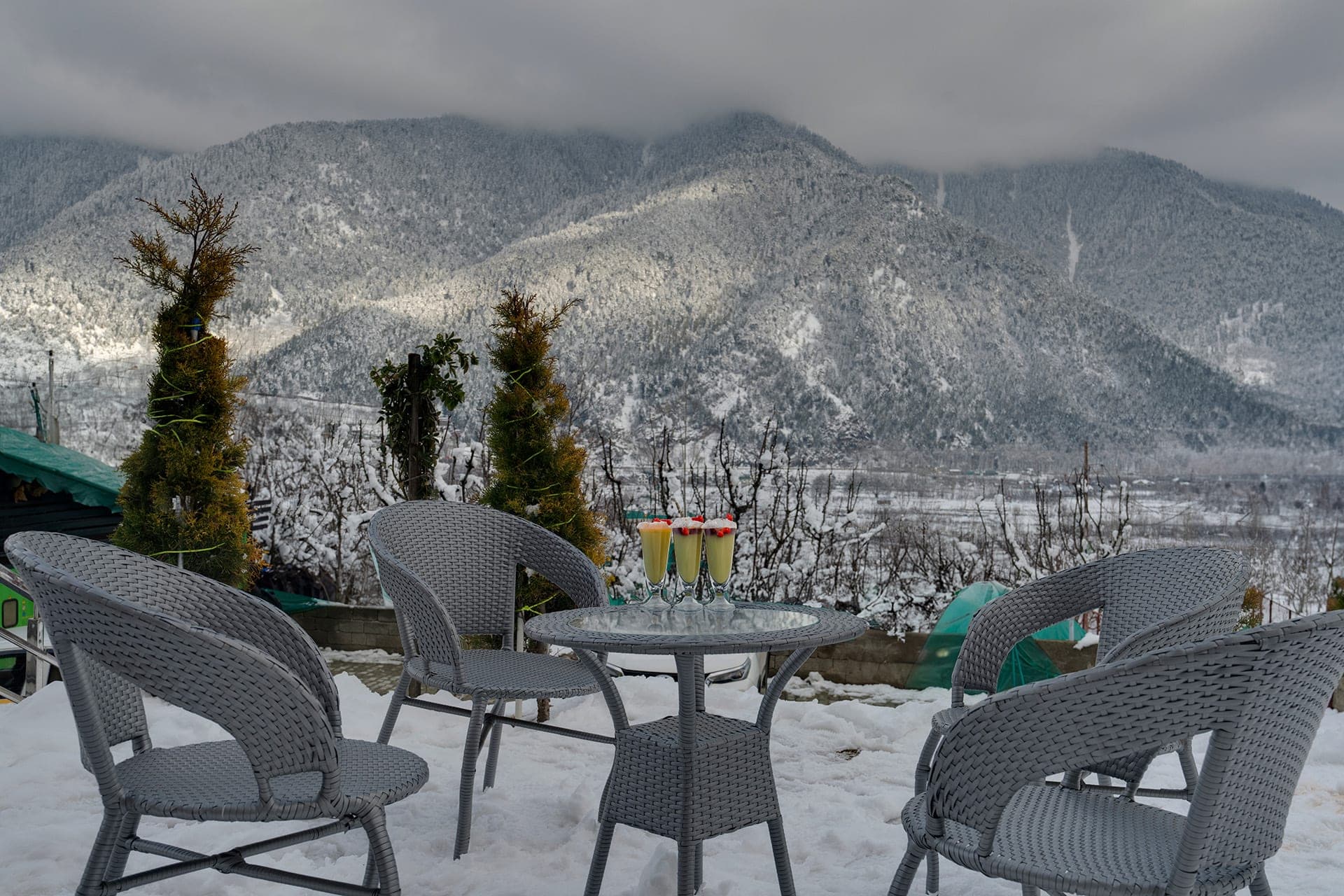 Terrace seating at Hotel Sparrow overlooking snow-dusted Himalayan mountains